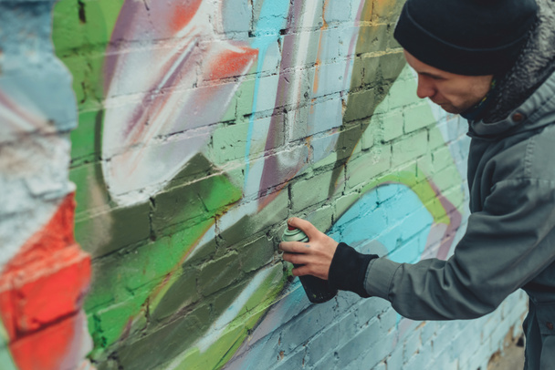 Sokak sanatçısı duvarlara renkli grafiti yapıyor. - Fotoğraf, Görsel
