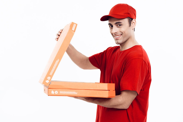 Man of Arab appearance works in the delivery of pizza. Man in red uniform is holding a box of pizza. - Valokuva, kuva