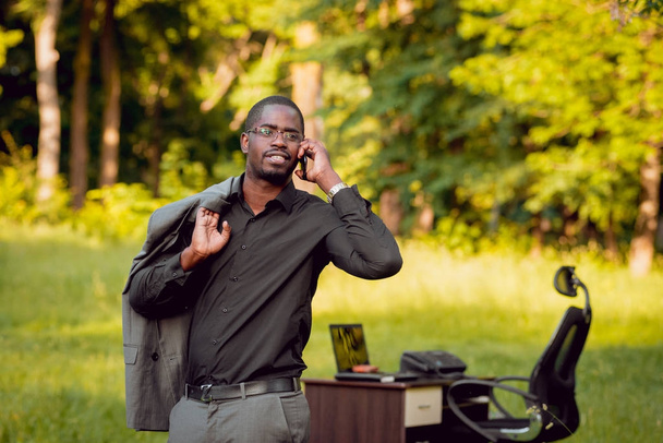 Young african american businessman at work in park. Concept of remote work. - Fotografie, Obrázek