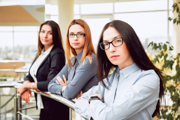 Три молодые предпринимательницы в офисном зале
 - Фото, изображение