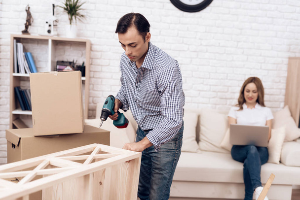 Man handyman is engaged in assembly of furniture. Repairman is engaged in repairing furniture. - Φωτογραφία, εικόνα