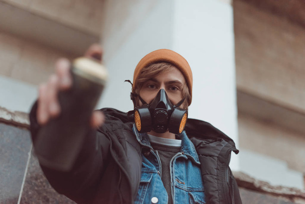 selective focus of man in respirator holding can with spray paint - Foto, Imagem