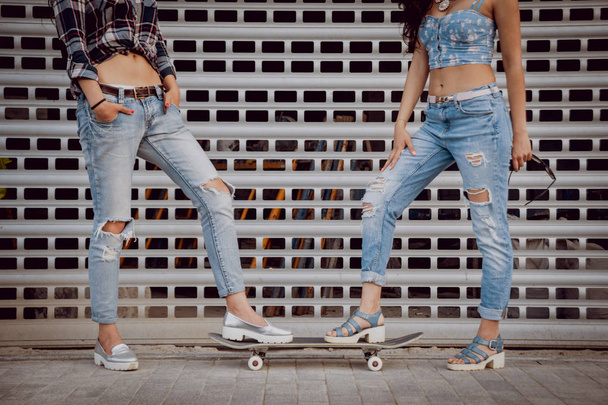 Two young girls posing  with skateboard outdoors - Фото, зображення