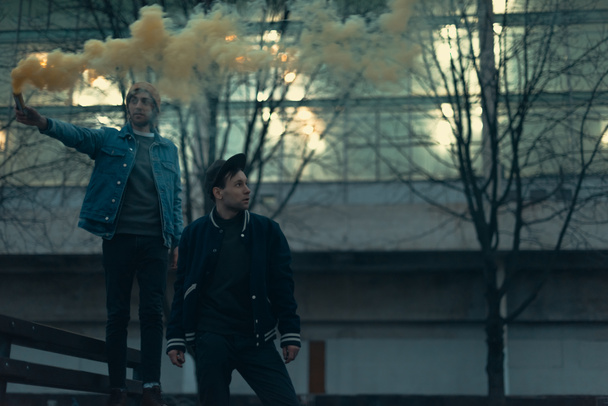 nuoret miehet savupommin kanssa kaupungissa
 - Valokuva, kuva