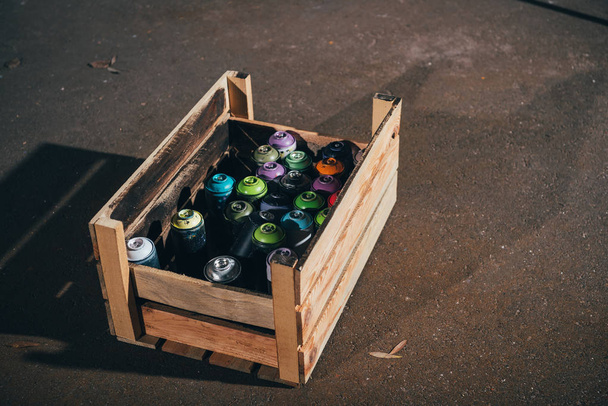 latas con pintura en aerosol en caja de madera
 - Foto, imagen