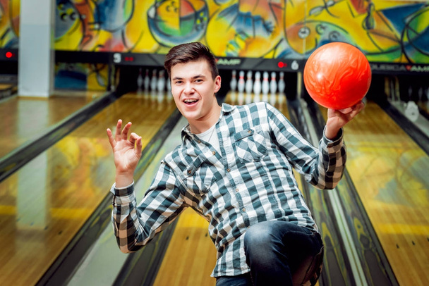 Happy young man at the bowling alley with ball - Foto, Bild