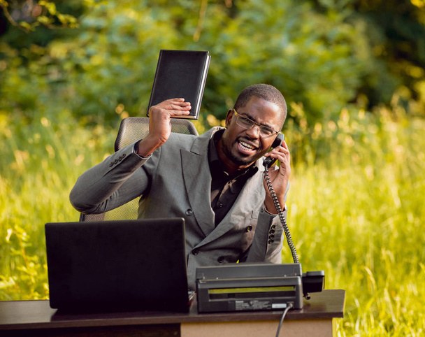 African buisnessman working in park. Concept of remote work. - Foto, afbeelding