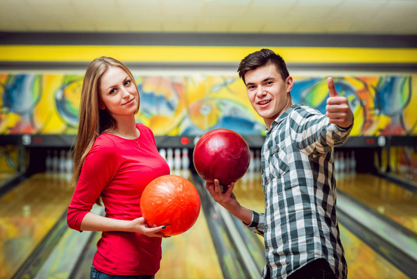 Young caucasian couple at the bowling alley posing with balls - Fotografie, Obrázek