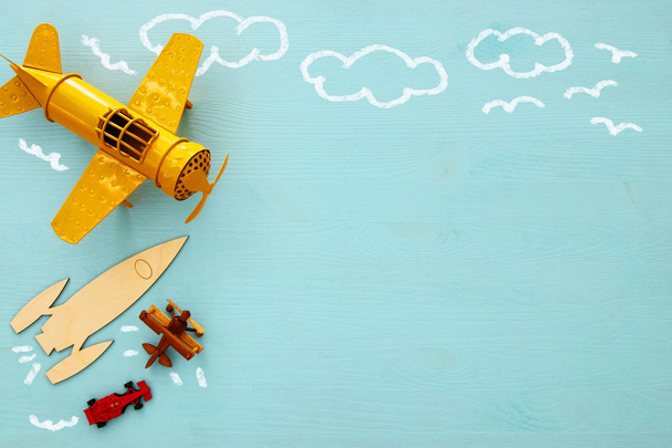 Concept of imagination, creativity, dreaming and childhood. Old toys: car, rocket and plane with info graphics sketch on the blue background. - Foto, Imagen