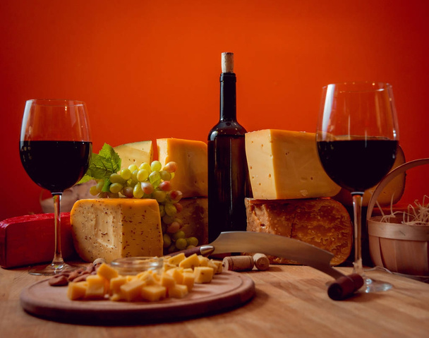 Beautiful and rich composition with assorted cheeses and wine with nuts and grape - Фото, зображення