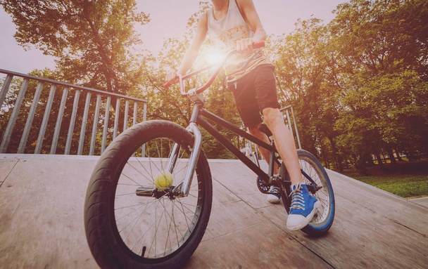 Teenager riding BMX in skate park. - Zdjęcie, obraz