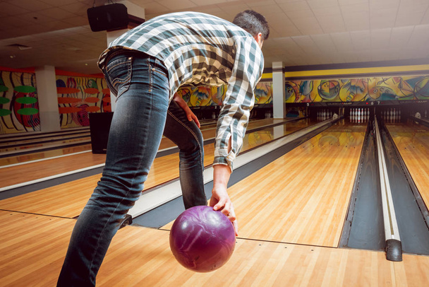 Young caucasian man having fun at the bowling club - Foto, imagen