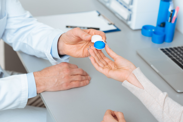 Oříznout záběr oftalmolog kontaktní čočky dát pacientovi v klinice - Fotografie, Obrázek