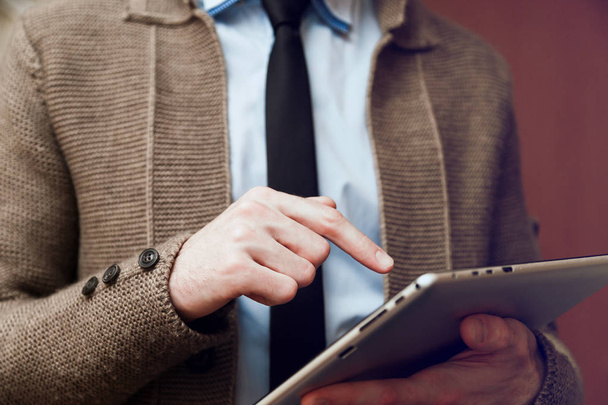 Vista de cerca del hombre que sostiene la tableta digital en la mano y el uso de la pluma electrónica mientras trabaja en la oficina
 - Foto, imagen