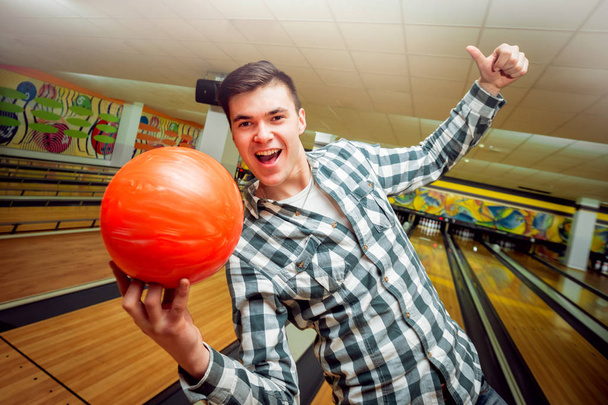 Young caucasian man having fun at the bowling club - Φωτογραφία, εικόνα