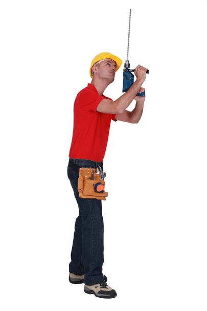 Tradesman adding an extension to his screw gun - Zdjęcie, obraz