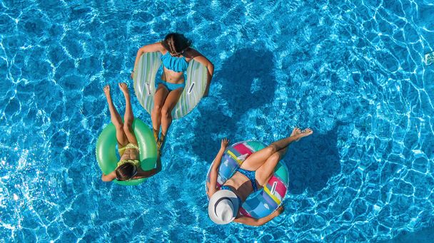 Ailesinin Yüzme Havuzu yukarıdan, mutlu anne ve çocuklar hava üstten görünüm şişme halka çörek üzerinde yüzmek ve su ailecek tatile eğlenmek - Fotoğraf, Görsel