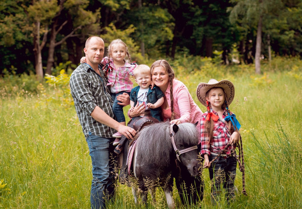 Cheerful family walks with pony horse in park - Φωτογραφία, εικόνα
