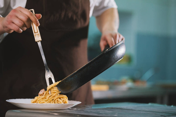 Šéfkuchař nabízí na desce v restaurantu špagety carbonara - Fotografie, Obrázek
