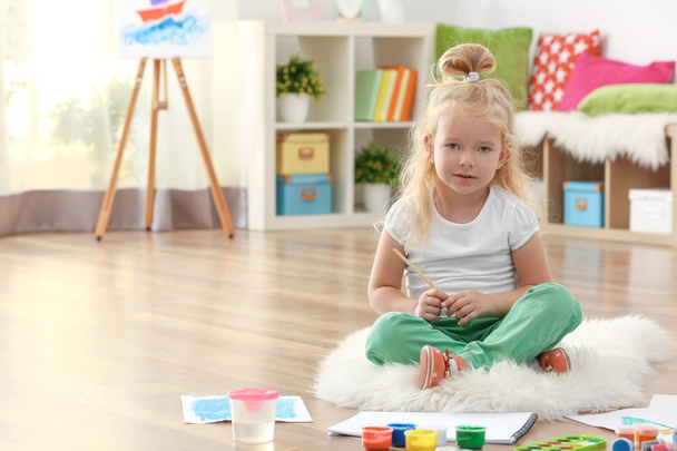 Cute girl painting picture on sheet of paper, indoors - Foto, afbeelding