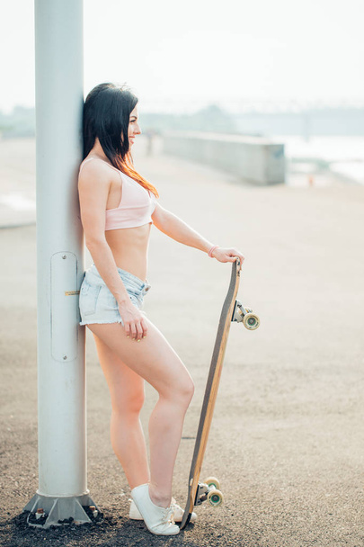 pretty woman posing wit longboard in a street - Photo, image