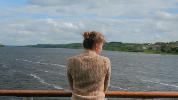 Νεαρή γυναίκα στέκεται στο κατάστρωμα του κρουαζιερόπλοιου και κοιτάζοντας ποταμού και του τοπίου - Πλάνα, βίντεο