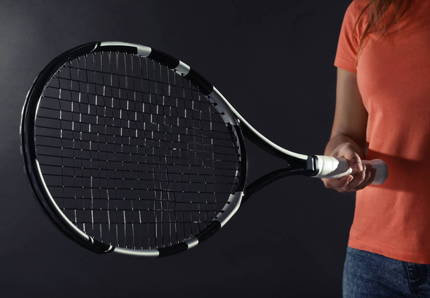 Woman with tennis racket on dark grey background - Fotoğraf, Görsel