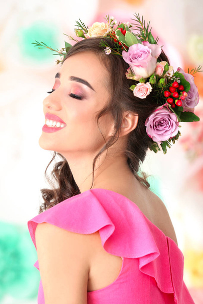 Beautiful young woman with flower wreath on color background - Fotografie, Obrázek