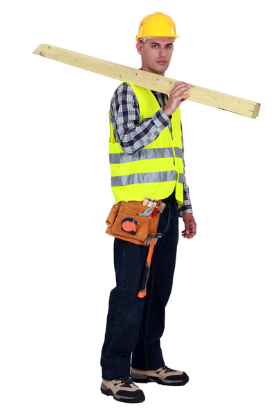 Craftsman carrying two wooden boards on his shoulder - Fotoğraf, Görsel