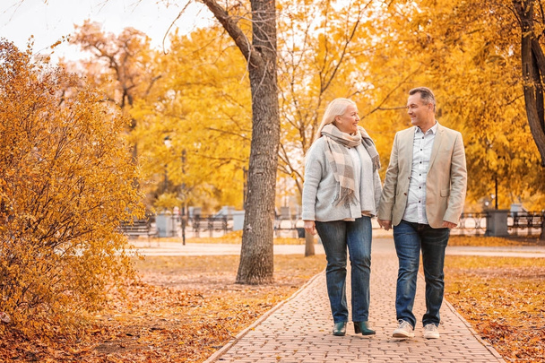 Starsza para spaceru w parku na jesienny dzień - Zdjęcie, obraz