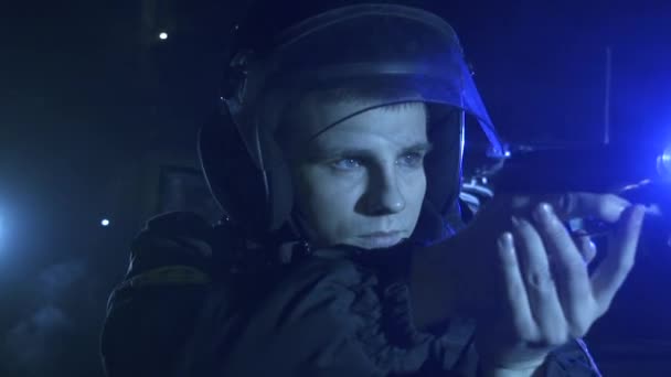 Офицер полиции с пистолетом на фоне мерцающих мигалок
 - Кадры, видео