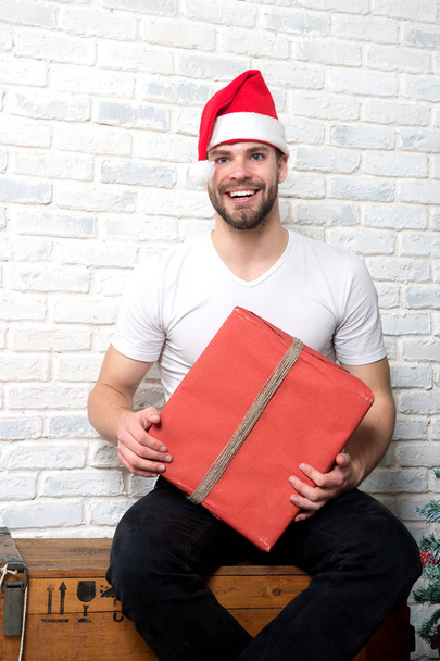 Man santa smile with red box on white brick wall - Foto, afbeelding