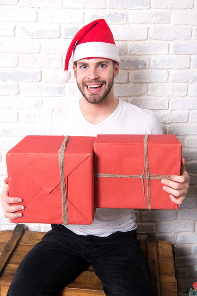 Man santa smile with boxes on white brick wall - Foto, afbeelding