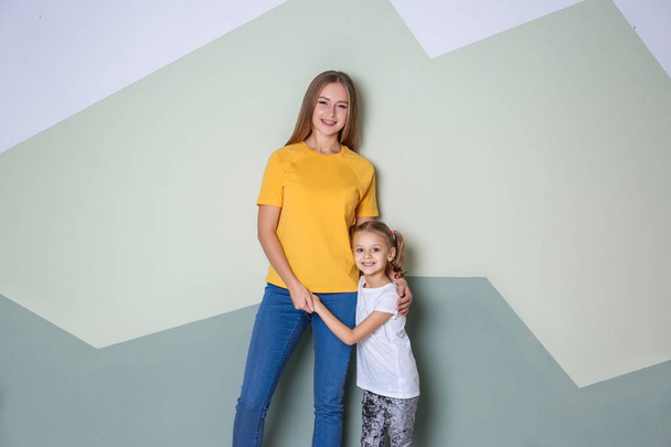 Madre felice e sua figlia contro la parete di colore nella stanza dei bambini
 - Foto, immagini