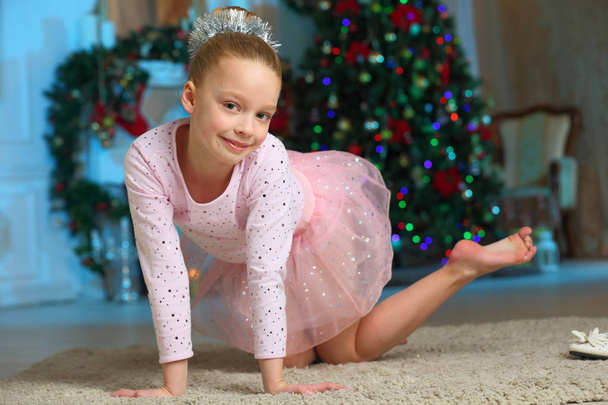 Pretty charming beautiful artistic blond baby girl in Christmas costumes. Beautiful blonde child girl in a New Year's pink suit snowflakes. - Φωτογραφία, εικόνα