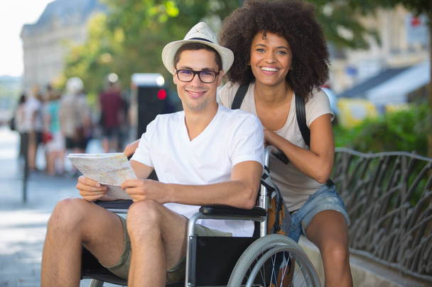 handicapped man in wheelchair and girlfriend on holidays - Φωτογραφία, εικόνα