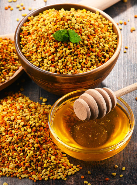 Bowls with bee pollen and honey on kitchen table - Photo, Image