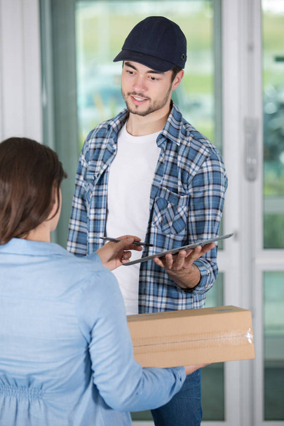 woman getting a parcel from delivery man - Foto, Imagen