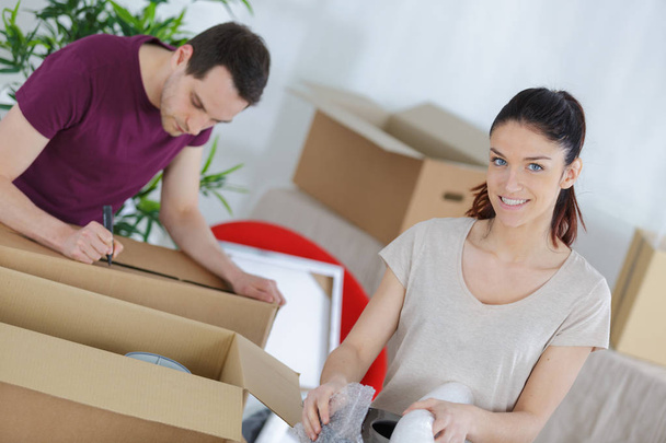 couple preparing boxes man marking contents with pen - Photo, image