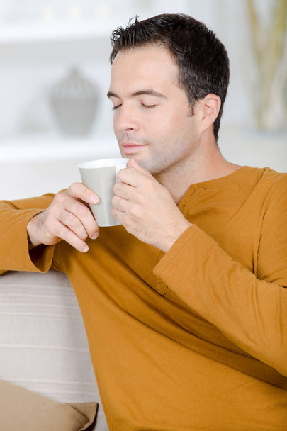 Man enjoying the aroma from his coffee cup - Foto, imagen