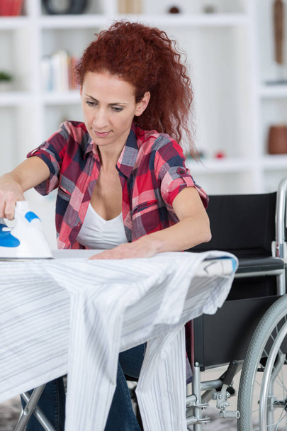 disabled woman during ironing at home - Valokuva, kuva
