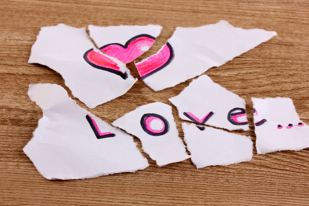 zerrissenes Papier mit Wörtern Liebe Nahaufnahme auf Holztisch - Foto, Bild