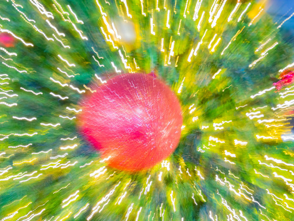 ζουμ έκρηξη φωτός θαμπάδα εικόνας του σπινθηρίσματος μπάλα στο χριστουγεννιάτικο δέντρο της ερυθρελάτης, τεχνητές πευκοβελόνες, bokeh Led διακοσμητικά φως defocused φόντο και υφή, για παραμονή των Χριστουγέννων, το νέο έτος κόμμα εορτής - Φωτογραφία, εικόνα