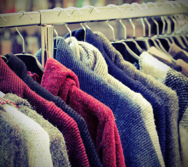 много винтажной подержанной одежды на открытом блошином рынке
 - Фото, изображение
