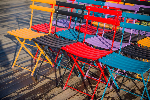 Colored folding chairs for a seminar or training on an open wooden terrace - Valokuva, kuva