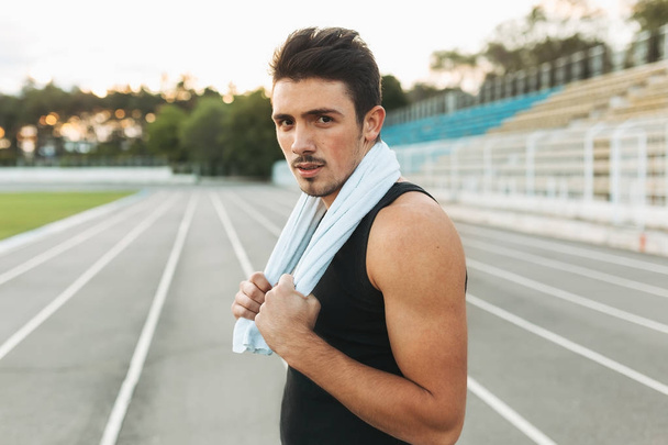 Retrato de um homem fitness com toalha nos ombros descansando depois
 - Foto, Imagem
