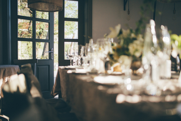 結婚式。バンケット。お、キャンドルや花で飾られたテーブル カトラリー、食器とテーブル クロスで覆われています。ドアを開けるとレストラン入り口 - 写真・画像