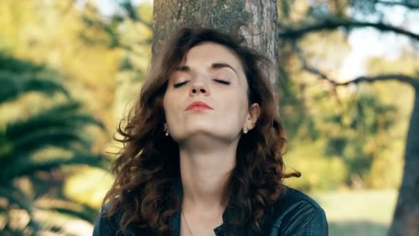 sexy woman sad and stressed under a tree, waiting for her husband - Footage, Video
