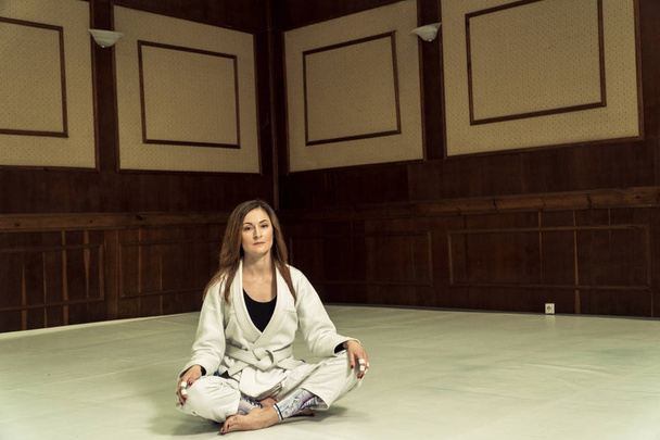 A girl in a kimono kneads before training in judo and jujitsu - Photo, image