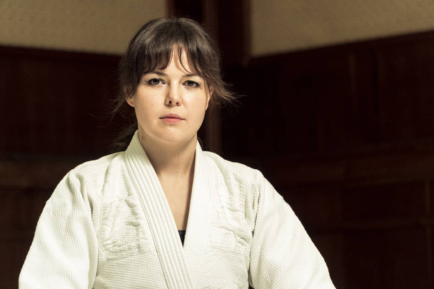 A girl in a kimono kneads before training in judo and jujitsu - Foto, imagen